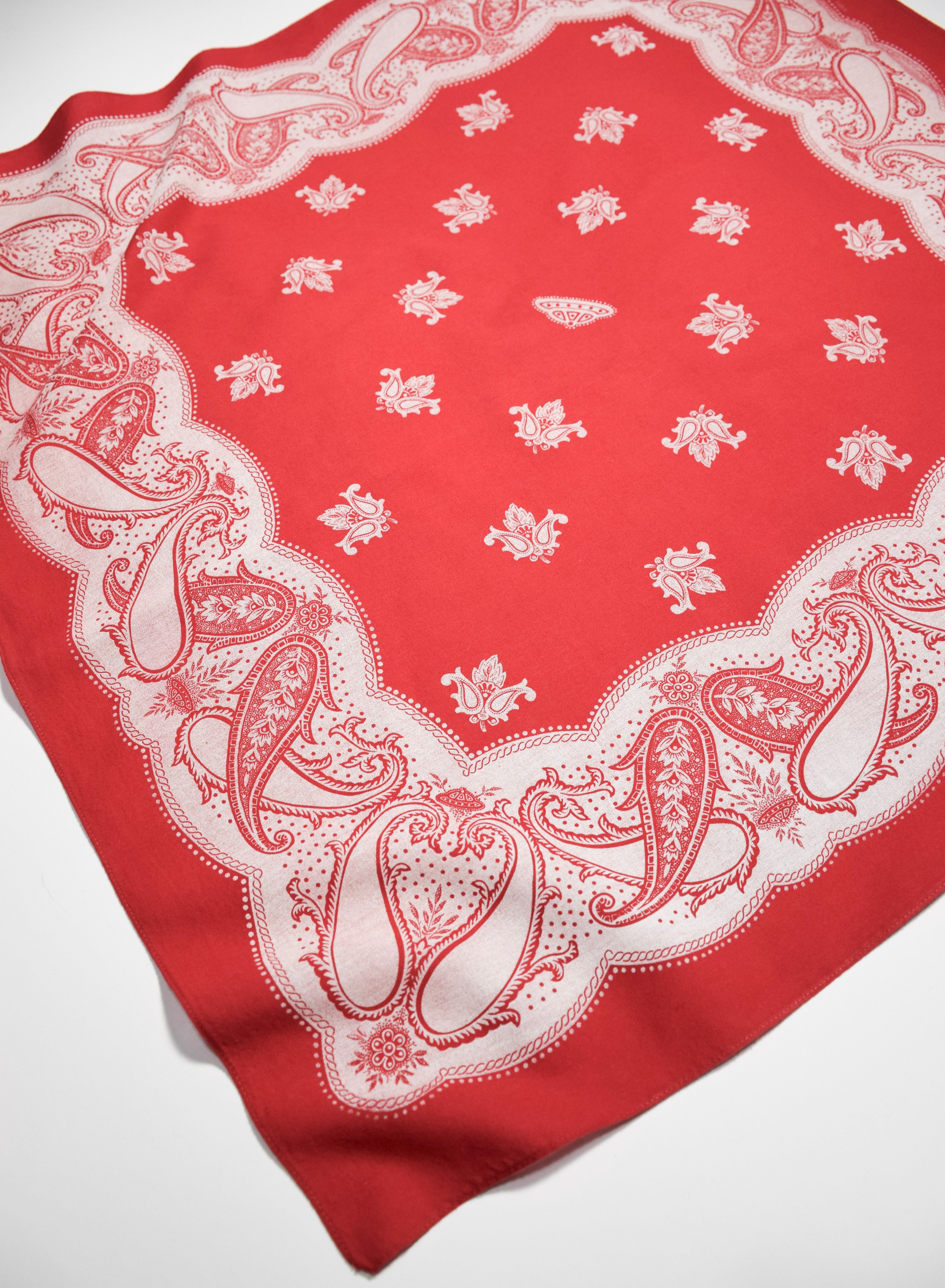 Red bandana with white paisley pattern on a white background